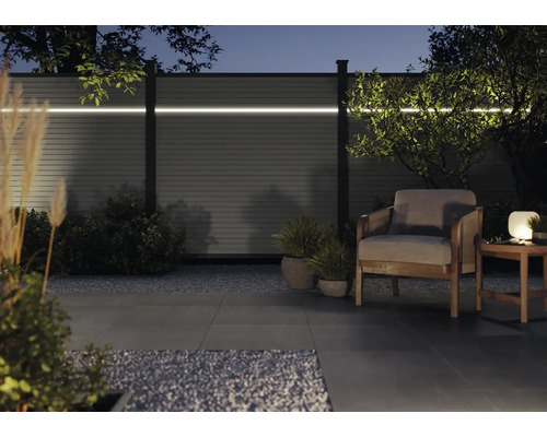 Moderne Gartenszene mit Zaun, Beleuchtung und Sitzbereich für entspannte Abende