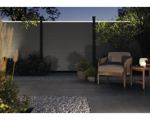 Garten mit beleuchtetem Zaun, Sessel und Tisch