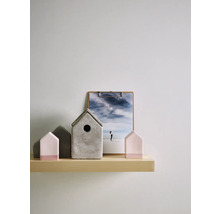 Dekorative Szene mit Betonhäusern und Klemmbrett auf einem Regal