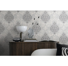 Dekoratives Wohnzimmer mit gemusterter Tapete und Holzkommode