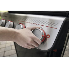 Person bedient Drehknopf am Gasgrill