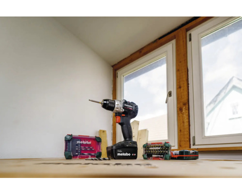 Akkuschrauber von Metabo mit Bohrer- und Bit-Set vor einem Fenster