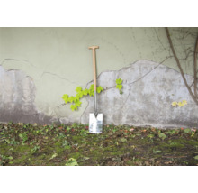 Spaten mit Holzgriff an einer Wand