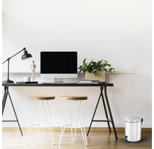 Büroszene mit Schreibtisch, Computer, Lampe, Stühlen und einem Treteimer