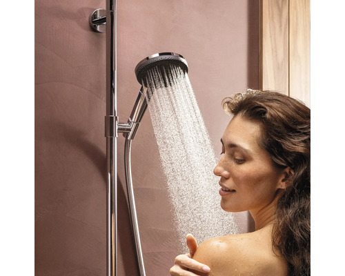 Frau unter einer Duscharmatur mit laufendem Wasser