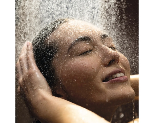 Frau genießt Dusche mit geschlossenen Augen