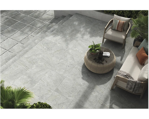 Terrasse mit grauen Steinzeugfliesen und Gartenmöbeln