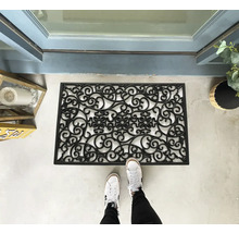 Fußabtreter aus Gummi mit dekorativem Muster vor einer Haustür