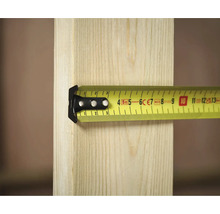 Ein gelbes Rollbandmaß von Stanley misst ein Stück Holz.