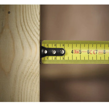 Gelbes Rollbandmaß misst ein Stück Holz