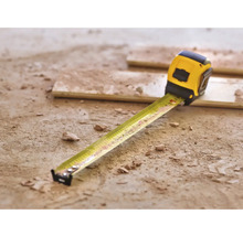 Gelbes Rollbandmaß auf dem Boden