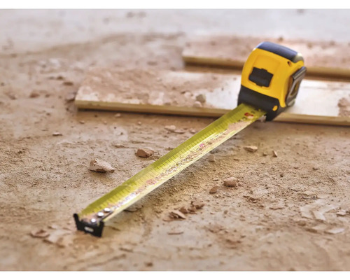 Gelbes Rollbandmaß auf dem Boden