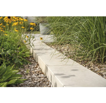 Gartenweg aus Betonsteinen mit Blumen und Ziergräsern