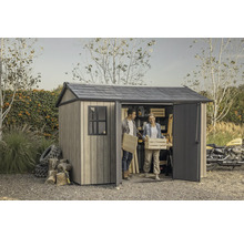 Gartenszene mit Gerätehaus, zwei Personen tragen Holzkisten