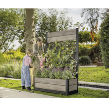 Frau und Kind bepflanzen einen Pflanzkasten mit Rankgitter im Garten.