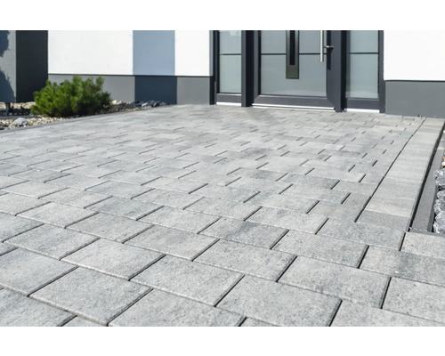 Gepflasterter Weg mit rechteckigen Pflastersteinen vor einem Haus