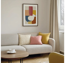 Wohnzimmer mit Sofa, Kissen, Tisch und gerahmtem Bild an der Wand