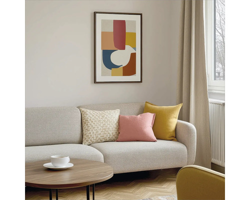 Wohnzimmer mit Sofa, Kissen, Tisch und gerahmtem Bild an der Wand