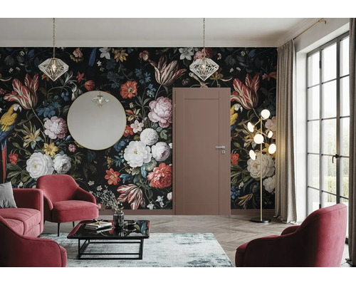 Wohnzimmer mit floraler Tapete, Tür, Spiegel, Pendelleuchten, Stehlampe, Teppich, Couchtisch und Sesseln