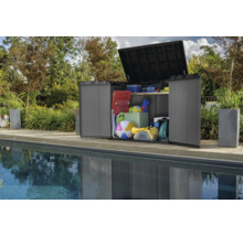 Geöffneter Geräteschrank aus Kunststoff mit verschiedenen Gegenständen neben einem Pool