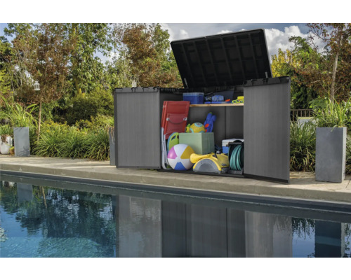 Geöffneter Geräteschrank aus Kunststoff mit verschiedenen Gegenständen neben einem Pool