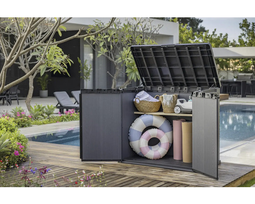 Geöffnete Aufbewahrungsbox aus Kunststoff mit Poolzubehör im Garten