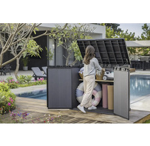 Gartenszene mit einer Frau, die einen Kunststoff-Geräteschrank am Pool benutzt, um Gegenstände zu verstauen