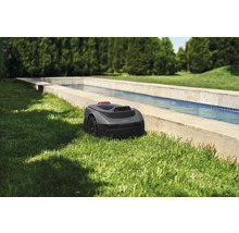 Mähroboter im Garten neben einem Wasserbecken