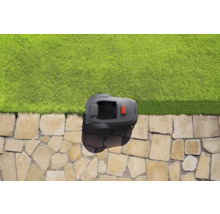 Rasenmähroboter auf Steinweg neben Rasenfläche