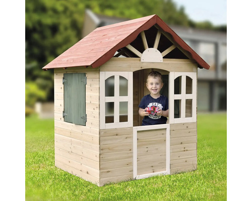 Kind im Holzspielhaus mit Fenster und Tür im Garten