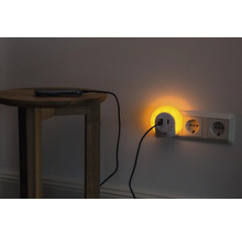 Nachttisch mit Smartphone, das über eine Steckdosenleuchte mit USB Anschluss geladen wird