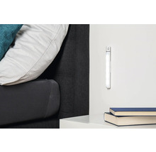 Szene mit einem Bett, Nachttisch, zwei Büchern und einer LED-Leuchte