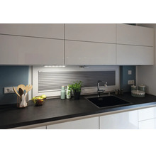 Moderne Küche mit weißen Schränken, dunkler Arbeitsplatte, Spüle und Küchenutensilien.