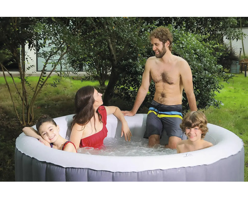 Familie entspannt in einem aufblasbaren Whirlpool im Garten.