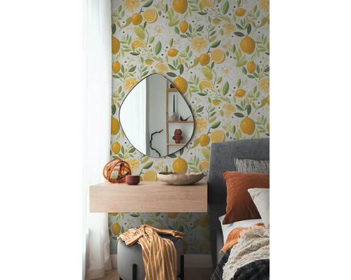 Schlafzimmer mit Wandtapete, verziert mit Zitronen und floralen Elementen, ergänzt durch einen Spiegel, ein schwebendes Regal und ein Bett.