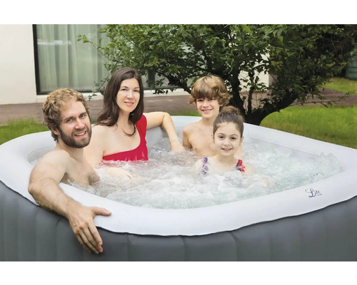 Familie entspannt in einem aufblasbaren Whirlpool im Garten.