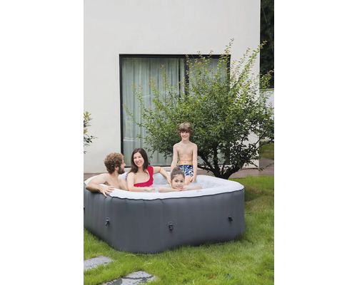 Familie entspannt in einem aufblasbaren Whirlpool im Garten.