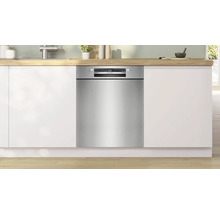 Einbaugeschirrspüler in einer modernen Küche mit weißen Schränken und Holzarbeitsplatte.