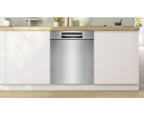 Einbaugeschirrspüler in einer modernen Küche mit weißen Schränken und Holzarbeitsplatte.