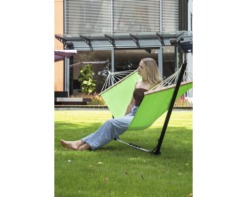 Freistehende Hängematte mit einer Frau, die im Garten entspannt.