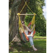 Frau entspannt in einer farbenfrohen Hängesessel-Schaukel, die an einem Baum befestigt ist.