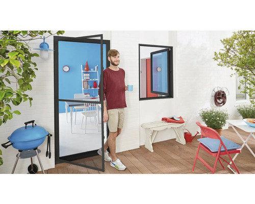 Terrasse mit Grill, Tisch und Stühlen, betreten durch eine Terrassentür mit einem Mann