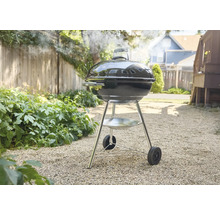 Kugelgrill im Garten mit Rauchentwicklung.