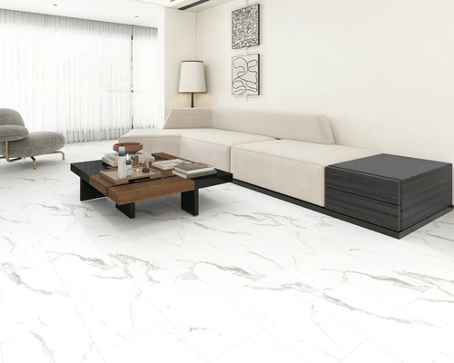 Heller Wohnraum mit Sofa, Couchtisch und Fliesenboden.