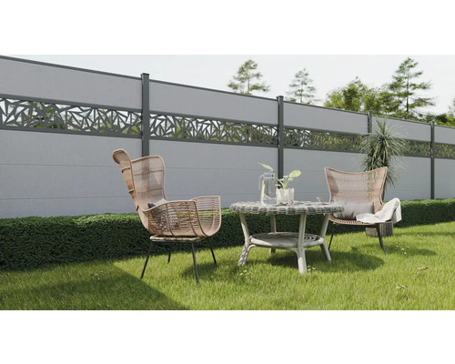 Gartenszene mit Betonzäunen, Rattansesseln und Beistelltisch auf einer Rasenfläche.