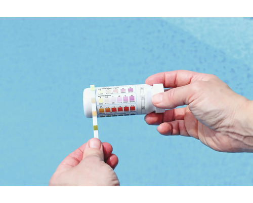 Eine Person testet das Poolwasser mit einem Teststreifen und einem Testkit.