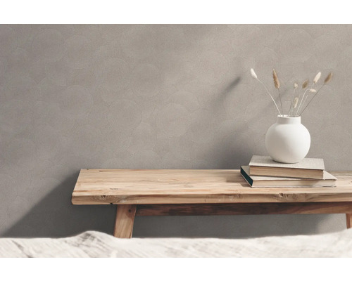 Wand mit Kreismuster, Holztisch, Vase und Bücher