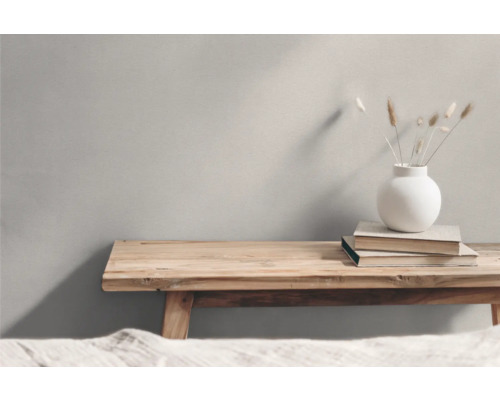 Holzbank mit Büchern und einer Vase mit Trockenblumen als Dekoration