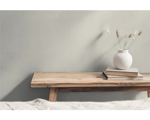 Dekoratives Arrangement mit Holzbänken, Büchern und einer Blumenvase
