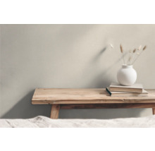 Helle Einrichtung mit Holztisch, Büchern und einer Vase mit Trockenblumen.